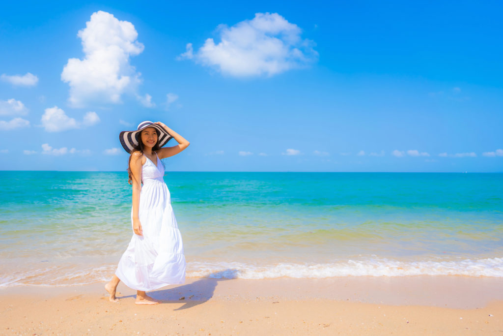 Portrait beautiful young asian woman happy smile leisure on the beach sea and ocean with blue sky white cloud for vacation travel