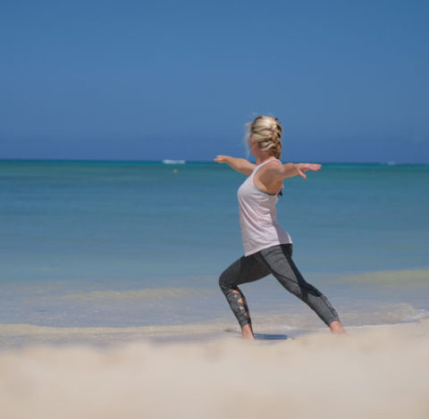 A woman is exercising by the beach